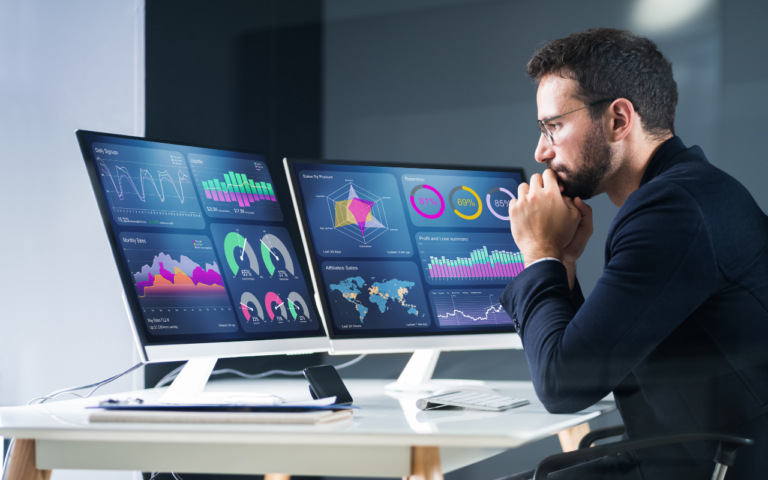 A man analyzing data on multiple digital dashboards with AI-driven insights and real-time analytics, representing modern data management trends for 2026